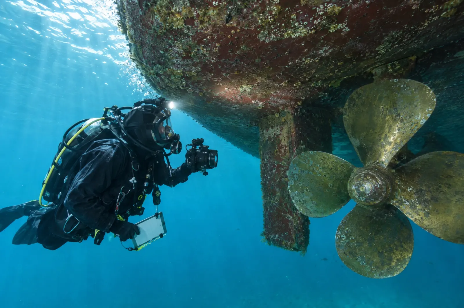 A survey diver photographs the propeller and bottom plating of a ferry