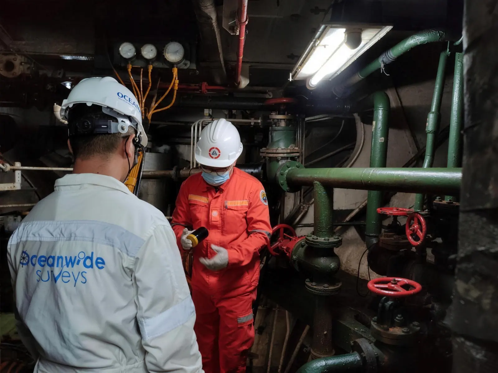 Oceanwide Surveys inspectors check engine room piping with the ship's engineer